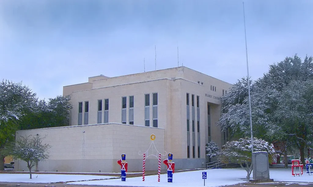 The exterior of the Ward County Courthouse building in Monahans, Texas, lightly covered in snow with holiday nutcracker decorations on the front lawn, representing the local service coverage area for a residential and commercial plumber Monahans, TX.