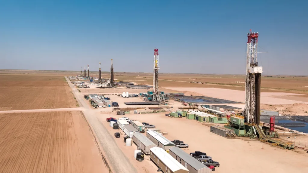 An aerial view of an active oilfield drilling site in West Texas where an industrial plumber Permian Basin TX manages complex piping, water infrastructure, and commercial plumbing systems.