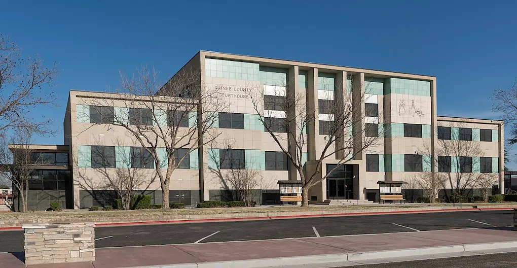 The exterior facade of the Gaines County Courthouse building under a clear blue sky, showcasing the local service area for an expert plumber Seminole, TX.